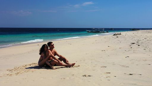 A Caucasian couple hugging and enjoying themselves on the beach of Gili Meno, Lombok, Indonesia
