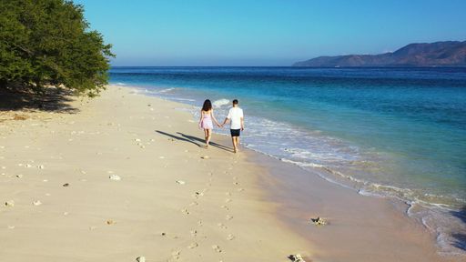 A Caucasian couple walking hand in hand on the beach in Gili Meno, Lombok, Indonesia