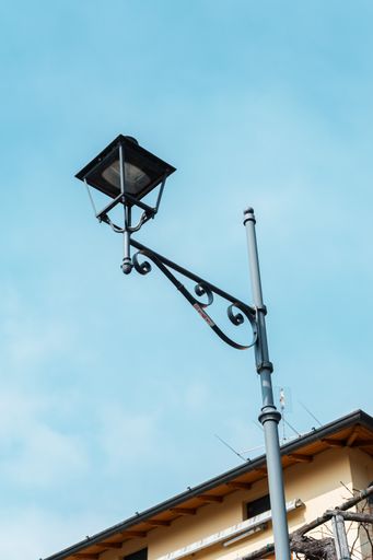 A vertical low angle shot of a vintage lamp in a blue sky