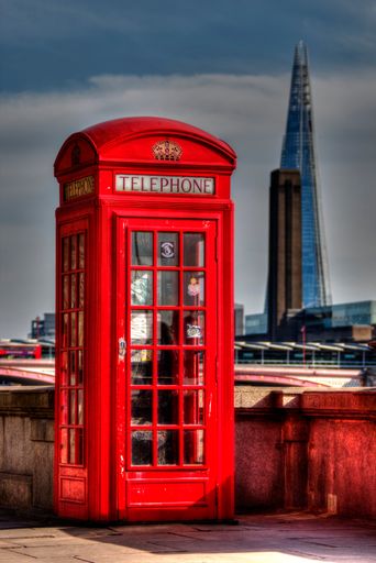 A vertical shot of a red telephone box near Waterloo with a viwe of The shard in the background.