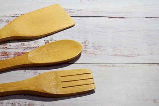 A close-up shot of kitchen spatulas on the wooden table.
