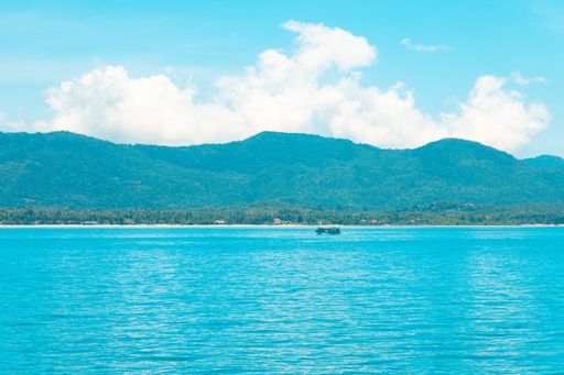 A beautiful shot of the sea with a boat in the distance under a blue sky at daytime