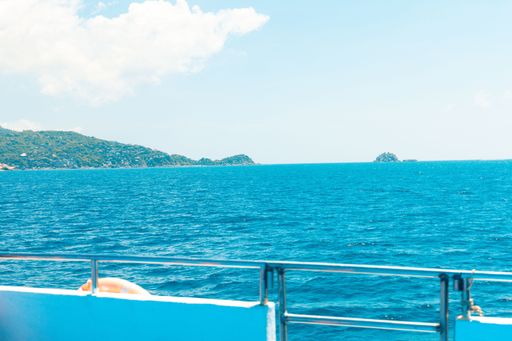 A beautiful shot from a boat on the water with mountain in the distance under a blue sky