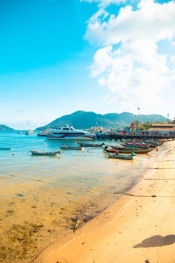 A vertical shot of boats near the water under a blue sky at daytime