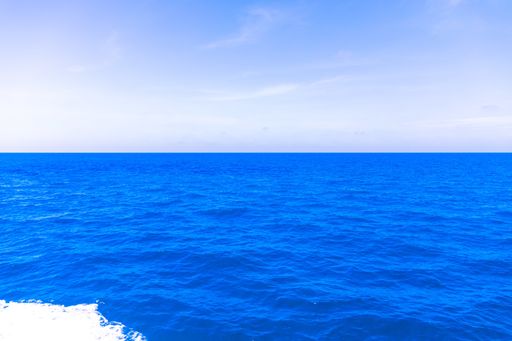 A beautiful shot from a boat of an empty sea under a blue cloudy sky