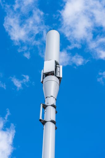 A vertical low angle shot of the 4G or 5G Cellular Antenna mast with cloudy sky in the background