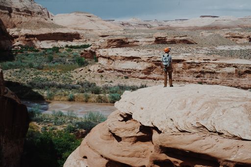 A man with a backpack standing on the cliffs of the canyon
