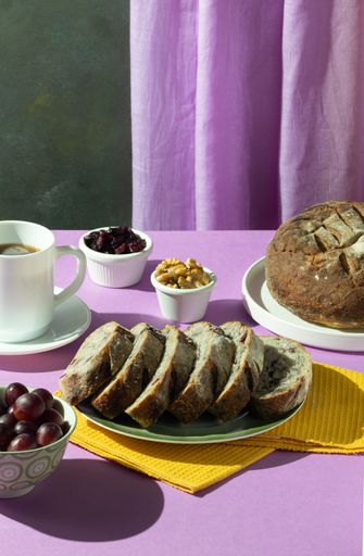 A vertical shot of freshly-baked fruity loaf with a  cup of tea on a table