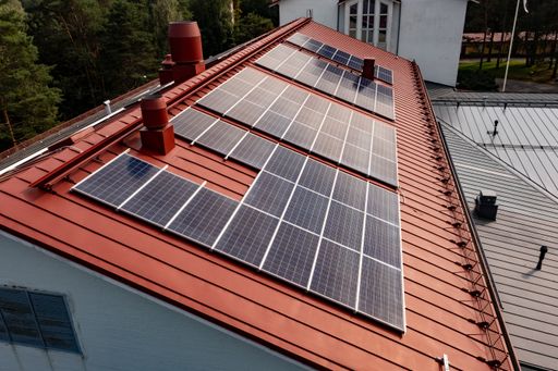 Aerial view low close of photovoltaic cells on a red house rooftop