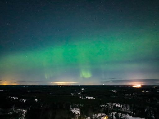 Aerial view of Aurora Borealis, Northern lights above rural Scandinavia