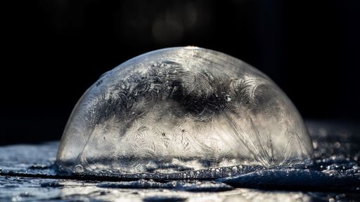 A closeup of a frozen bubble on a dark background