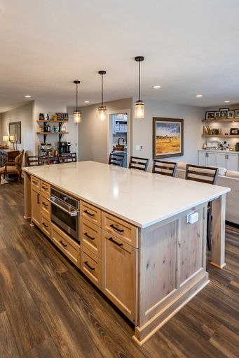 A vertical shot of a large white kitchen island in a beautiful room interior