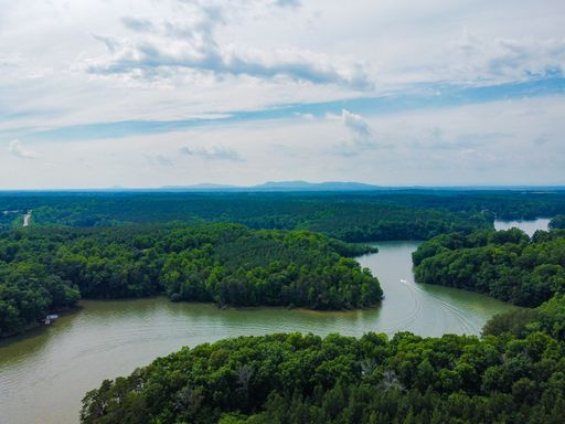 An aerial beautiful shot of Belews lake with the background of Hanging Rock on hot spring day