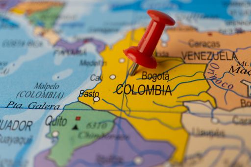 colombia marked on the map with a red pin, travel destination, planning. out of focus background