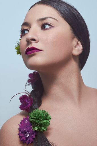 A vertical shot of a caucasian female with purple lips and flowers in her hair