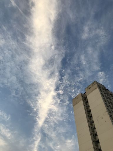 A low angle shot of the facade of the tall building under a scenic sky