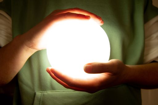 Moon lamp turn on with white background hold by two hands of a girl. Spherical lamp of a moon, planet
