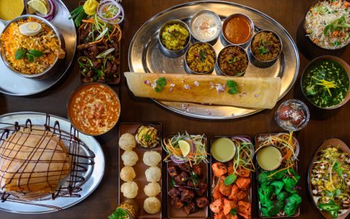 A top view of the Indian food Biryani with side dishes on a tablecloth