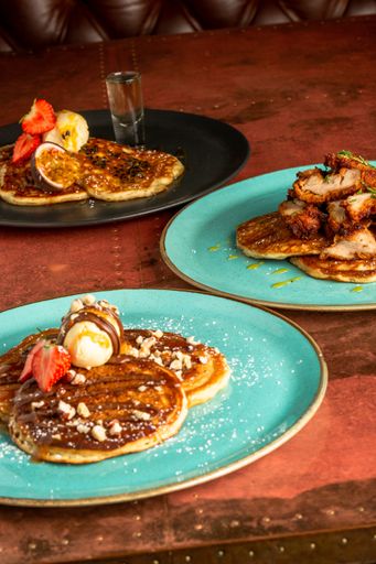 A vertical shot of tasty chocolate pancakes served with vanilla ice cream, nuts and different berries