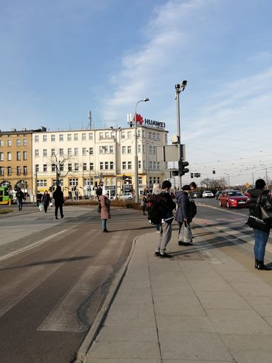 Group of people standing on a sidewalk on the Roosevelta street.