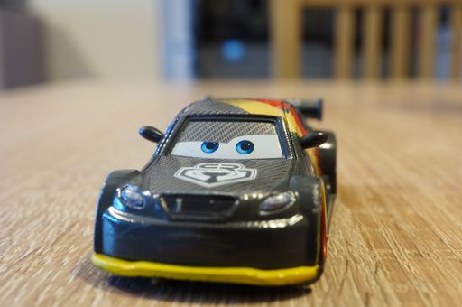 Mattel Disney Pixar Thomas Schnell toy race car from the Cars movie on a wooden table in front view