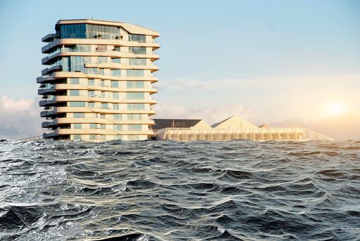 A scenic view of a hotel building surrounded by a blue ocean