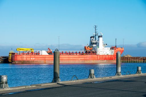 A scenic view of a big industrial vessel on the port in the blue sky background