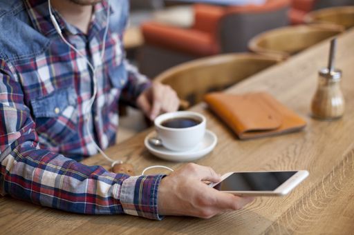 A close shot of a male using his smartphone with a blurred background