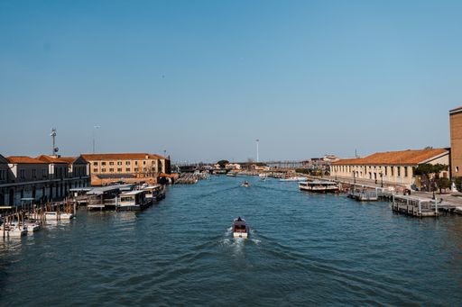 A picturesque river view in Venice, Italy, in warm sunlight and boats in the water