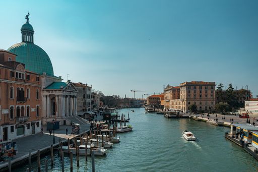 A picturesque river view in Venice, Italy, in warm sunlight and boats in the water