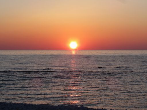 Warm sea sunset with cargo ship in the background
