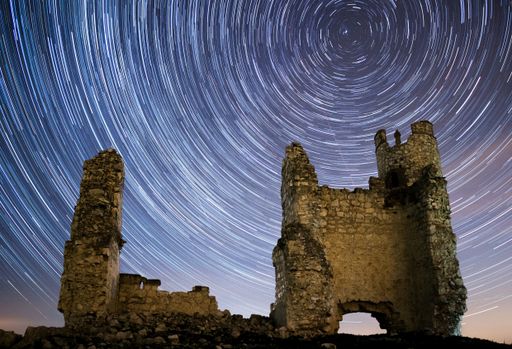 A beautiful long exposure shot of an old ruined castle with the stars trail