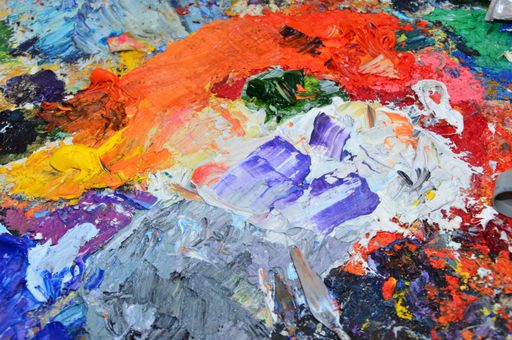 The palette of an artist with colorful mixed paints