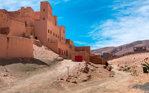 A typical village with mud brick houses in Morocco under a blue sky