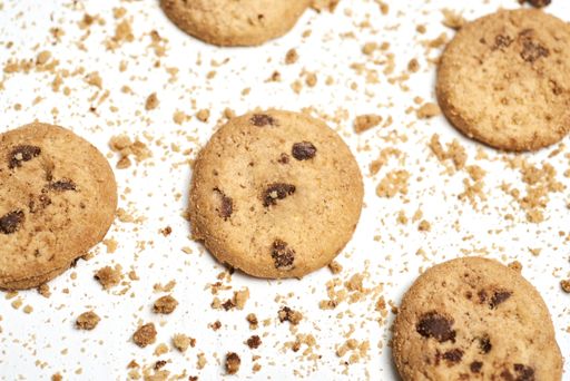 A selective focus shot of chocolate chip cookies on a white surface
