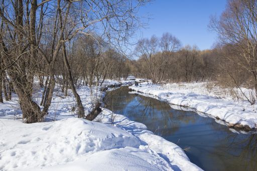 A landscape shot of Yauza river in Moscow, Russia during winter, with the ground covered in snow