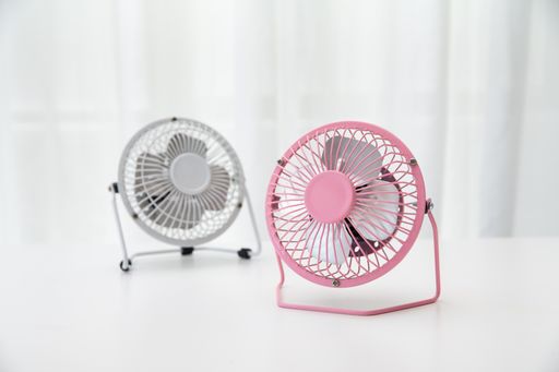 A closeup of small pink and white fans on a white table