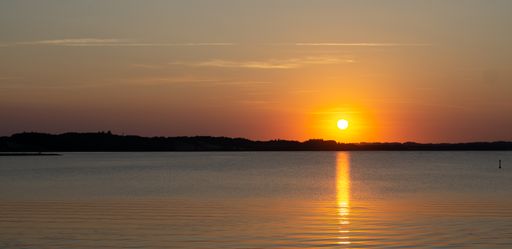 A panoramic view of the sunset reflected in the lake