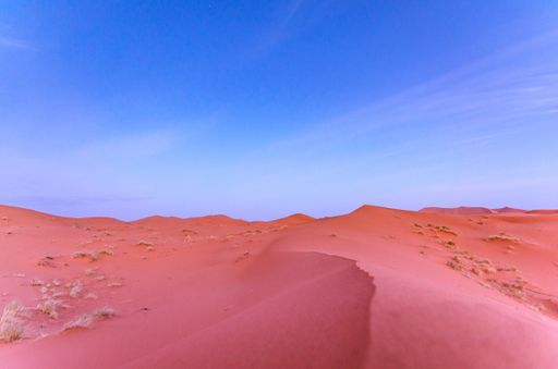 A landscape of sand dunes under a blue sky