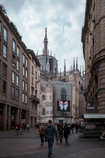 A vertical shot of the people walking on the street  near Duomo di  Milano Cathedral, Italy