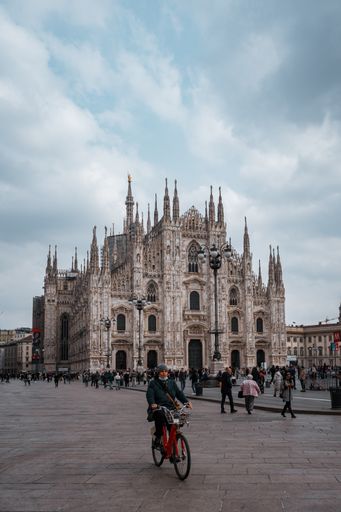 A beautiful vertical shot of the Milan Cathedral and people walking in the square in Milan, Italy