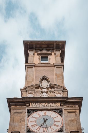 A vertical shot of a clock tower on the street in Milano, Italy