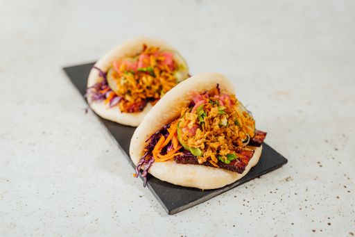A closeup shot of a steamed bao bun with vegetables