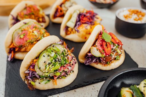 A closeup shot of steamed bao buns on a black surface