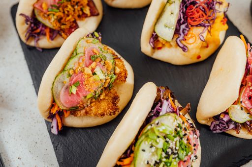 A closeup shot of steamed bao buns on a black surface