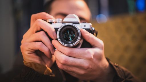 A close up shot of a photographer holding his camera