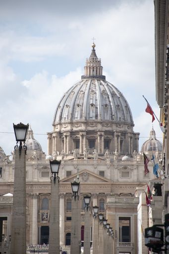 A vertical shot of Saint Peter's Square in Vatican City with a cloudy sky in the background