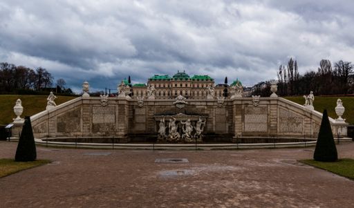 A low angle shot of Belvedere palace garden in Vienna, Austria with a cloudy sky in the background