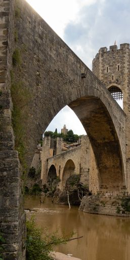 A vertical shot of Romanesque bridge over the Fluvia River in Besalu, Spain