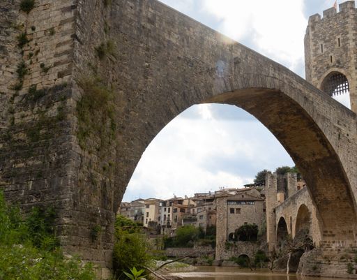 A low angle shot of Romanesque bridge over the Fluvia River in Besalu, Spain
